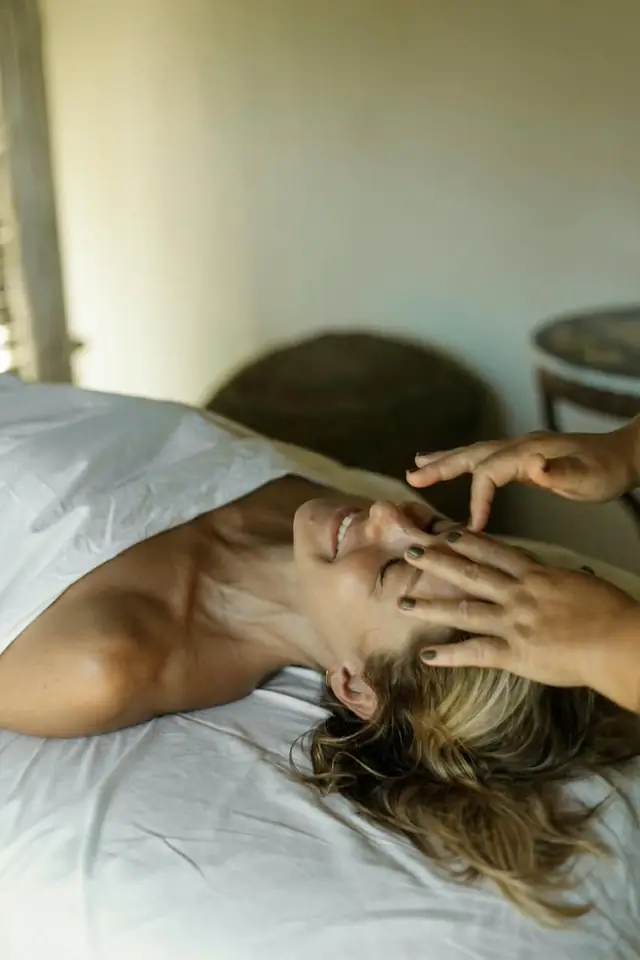 Massagem facial suave com a cliente de olhos fechados