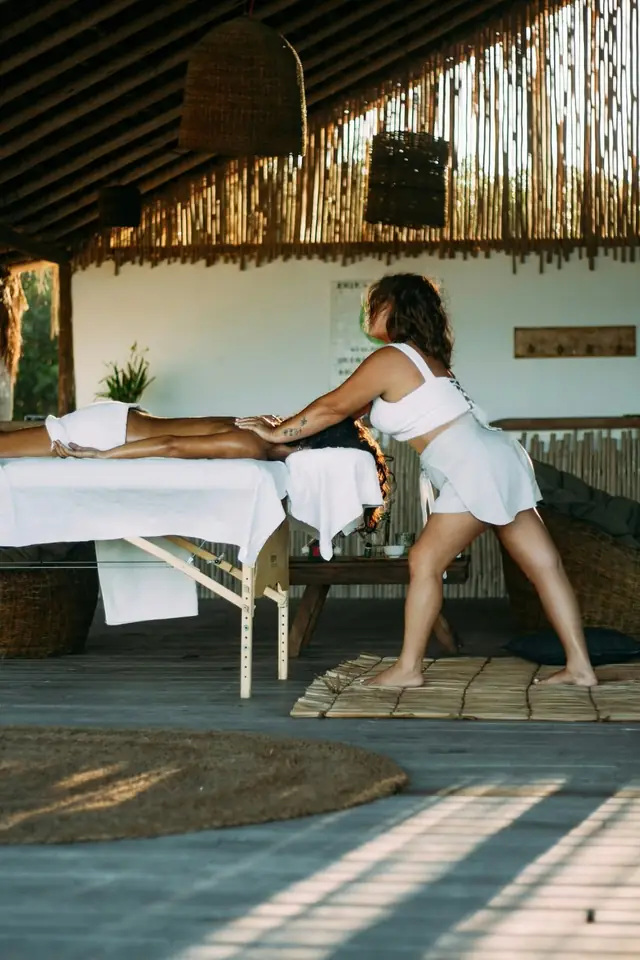 Érika aplicando massagem nos pés no espaço de palha